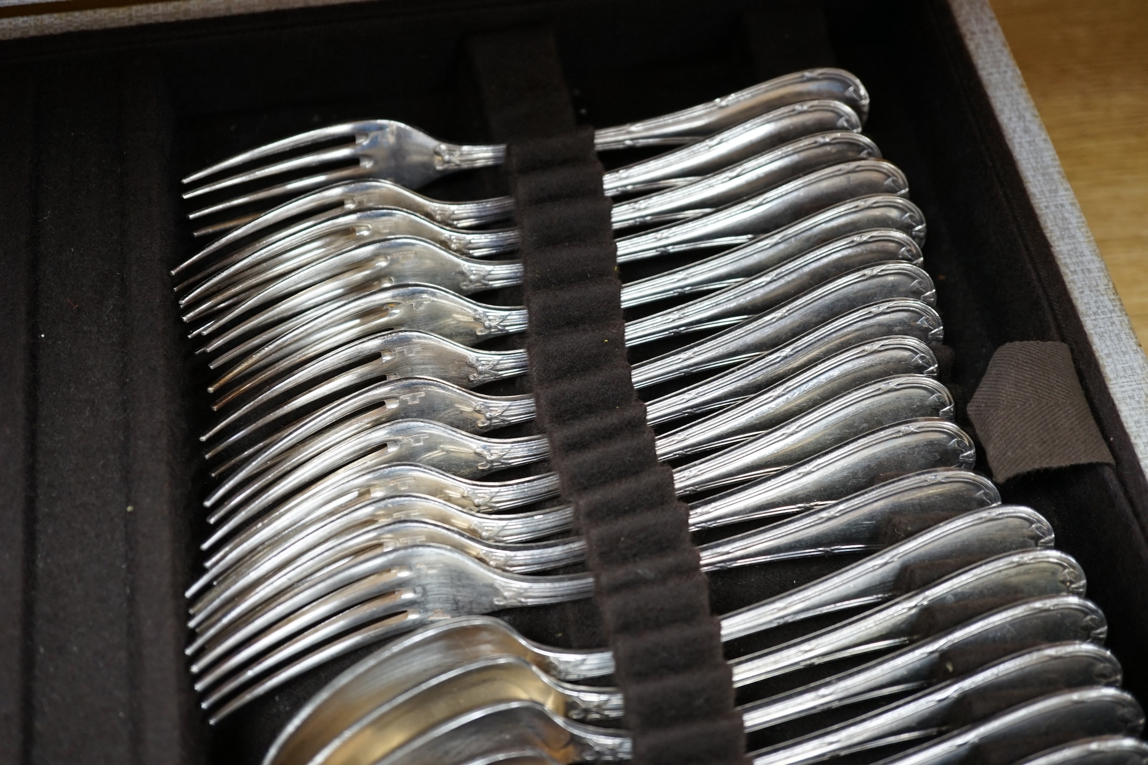 A cased canteen of French Christofle silver plated bow pattern cutlery, a twelve piece setting contained within two layers, case 49.5cm wide, 31cm deep, 13.5cm high